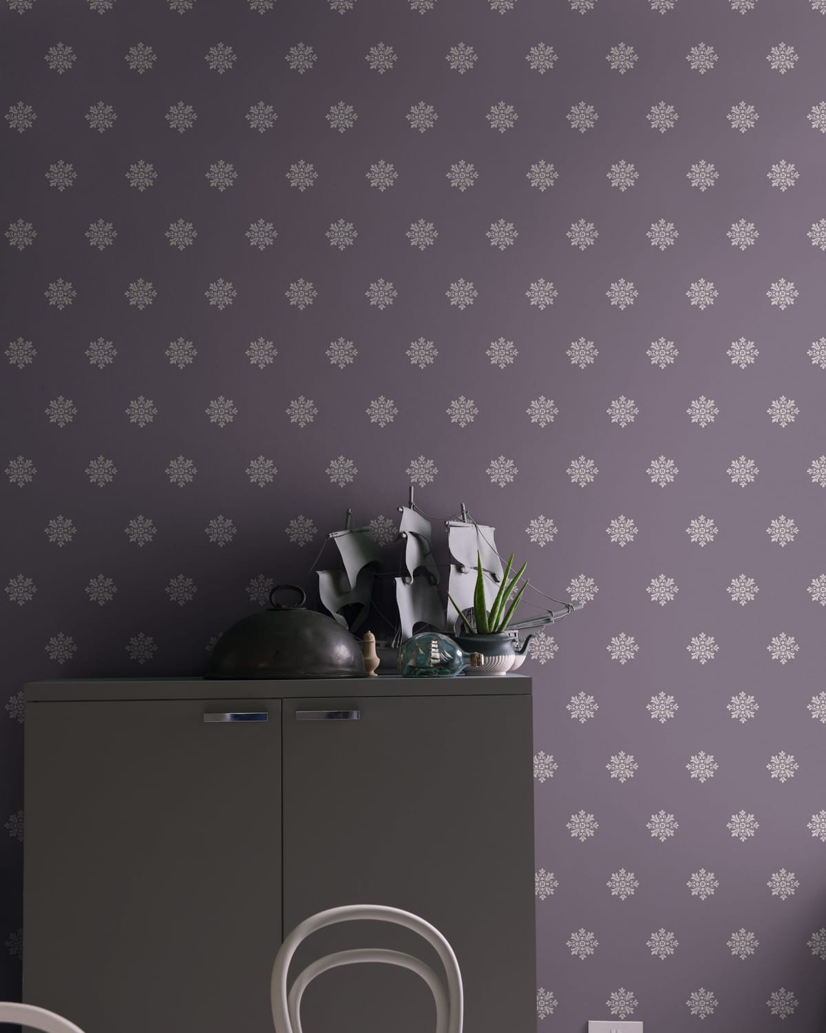 Zimmer mit heller, gemusterter Tapete und dunklem Vorhang